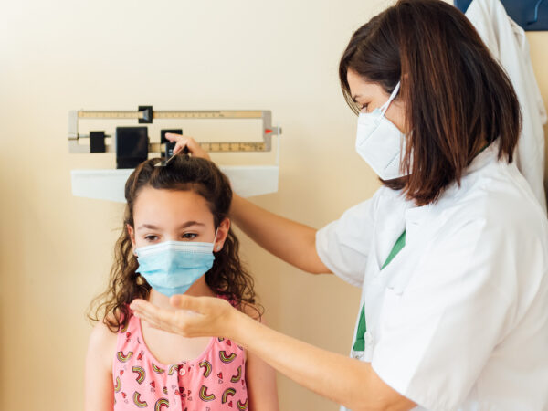 pediatrician and child wearing masks during appointment
